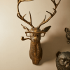 Bronze deer wall sculpture wearing glasses and a pipe, with additional quirky animal decor, reflecting Urban Goods & Garden’s playful and bold interior design flair in Wilmington, NC.